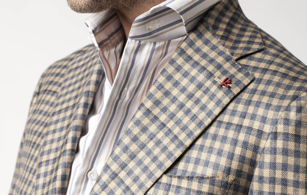 Up close shot of man in a patterned sports coat with a striped button-down shirt on